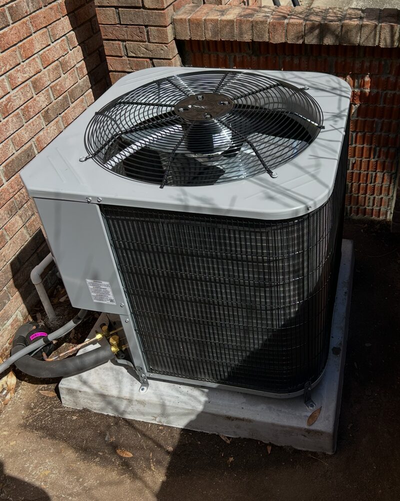 Outdoor AC condenser unit on a concrete pad during a service call